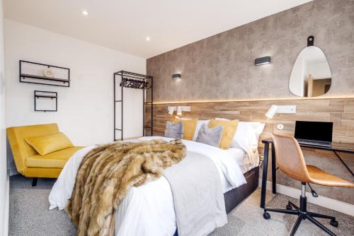 a bedroom with a large bed and a yellow chair at The Palm- City Centre 2 Bed, Sleeps 7, Netflix in Leicester