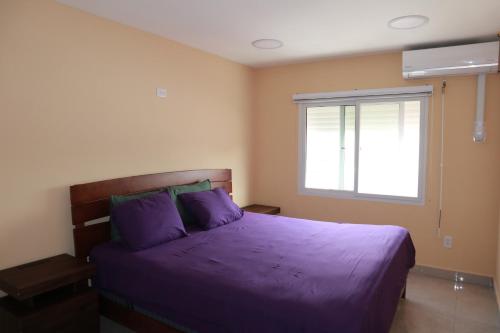 菲利普斯堡Panoramic Ocean View Flat-St Maarten的带紫色床和窗户的卧室