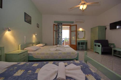 a hotel room with two beds with towels on them at Myriam Studios in Patitiri