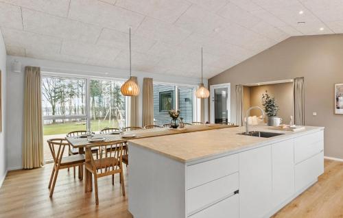 a kitchen with white cabinets and a table with chairs at Gorgeous Home In Hobro With Sauna in Hobro