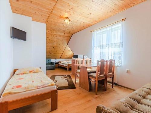 a room with a bed and a table and a couch at Pokoje Mariola in Karwia