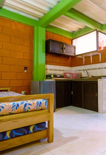 a kitchen with green walls and a wooden bench at Mi pueblo natal Aptos y habitaciones in Necoclí