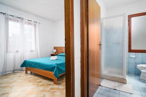 ブドーニにあるAppartamenti Lu Nibaruのベッドのある寝室とシャワー付きのバスルーム