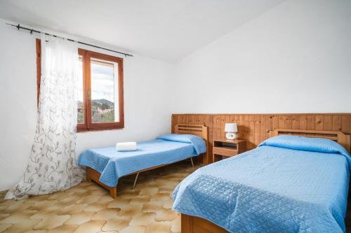 ブドーニにあるAppartamenti Lu Nibaruのツインベッド2台と窓のある寝室