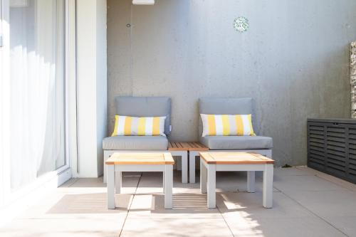 two chairs and a bench and a table on a porch at Elegant Suites Murten in Murten