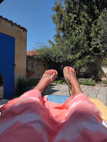 une personne assise sur un lit avec les pieds debout dans l'établissement Immeuble historique au pied du Château de Jonzac, à Jonzac