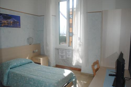 Habitación pequeña con cama y ventana en Affittacamere O Sole Mio, en La Spezia