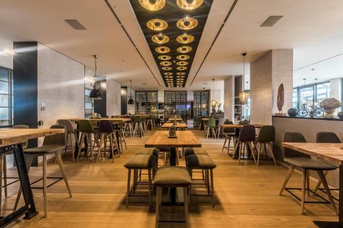 a restaurant with wooden tables and chairs in a room at Wellings Parkhotel in Kamp-Lintfort
