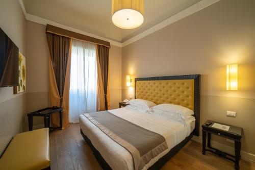 a bedroom with a large bed and a window at Hotel Palazzo San Lorenzo & Spa in Colle Val D'Elsa