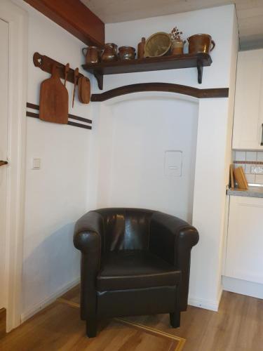 a black leather chair sitting in a room at Haus-an-de-Marsch in Midlum