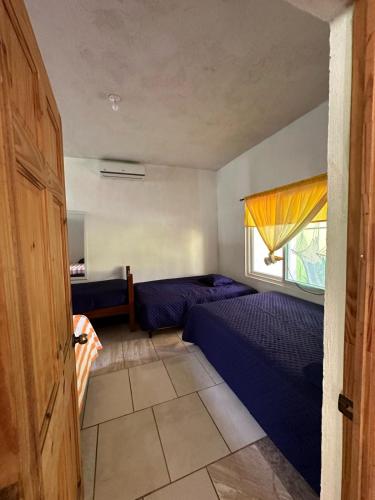 a small bedroom with two beds and a window at Chalet brisas del mar in Chiquimulilla