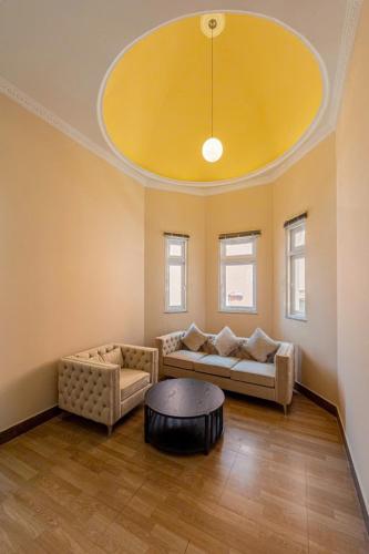 a living room with two couches and a yellow ceiling at Villa La Rose Blanc Thảo Điền in Ho Chi Minh City