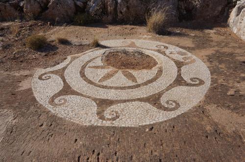 a drawing of a sun on the ground at Akrotirio Tainaro House in Marmari