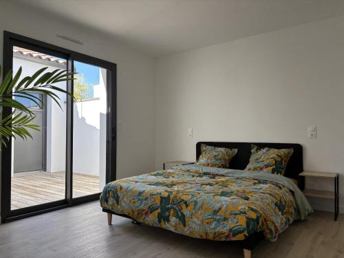 une chambre avec un lit et une porte coulissante en verre dans l'établissement Villa avec piscine 6 personnes, à Château-dʼOlonne