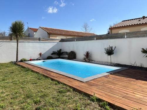 - une piscine sur une terrasse en bois à côté d'une maison dans l'établissement Villa avec piscine 6 personnes, à Château-dʼOlonne