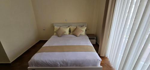a bed in a bedroom with a large window at Bole Central Apartment in Addis Ababa
