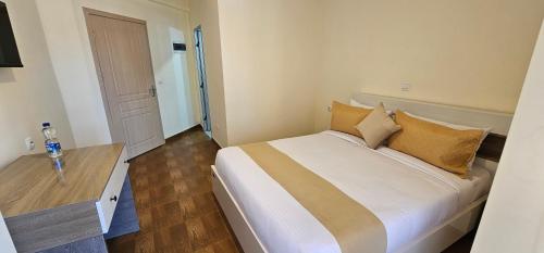 a bedroom with a large white bed and a wooden floor at Bole Central Apartment in Addis Ababa