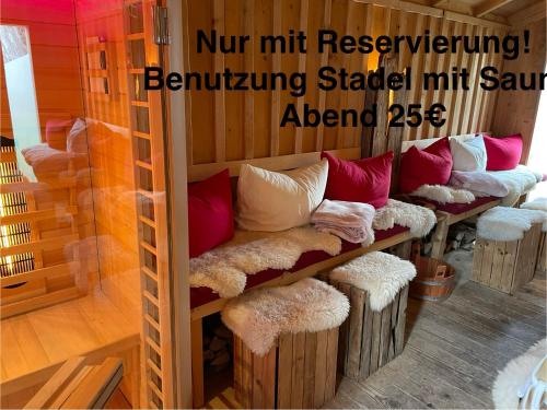 a row of benches with pillows on them in a room at Die Dirndlkönigin in Grünenbach