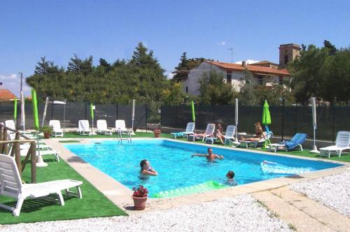 a group of people swimming in a swimming pool at Casa con piscina tra le colline in Pieve di Santa Luce