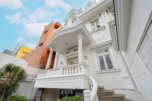 a white building with a white balcony on it at Villa La Rose Blanc Thảo Điền in Ho Chi Minh City
