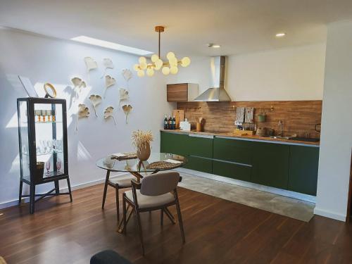 a kitchen with green cabinets and a table and chairs at Casa do Romezal in Peso da Régua