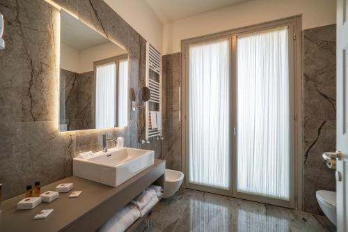 a bathroom with a sink and a mirror at Hotel Palazzo San Lorenzo & Spa in Colle Val D'Elsa