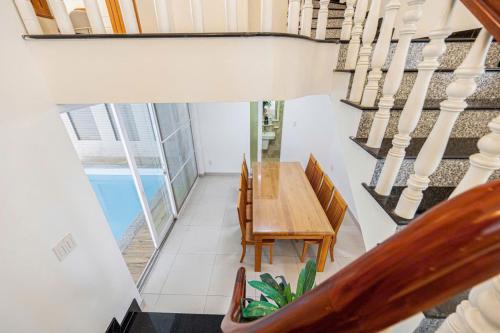 a dining room with a wooden table and chairs at Villa La Rose Blanc Thảo Điền in Ho Chi Minh City