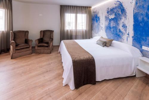 1 dormitorio con 1 cama grande y 2 sillas en Mònica Mar Apartments, en Cambrils