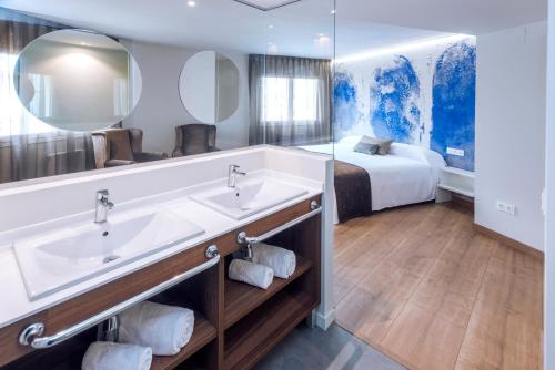 - Baño con lavabo doble y cama en Mònica Mar Apartments, en Cambrils