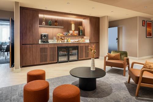 a living room with a table and chairs at Novotel Paris La Défense Nanterre in Nanterre