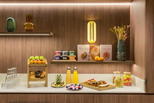 a counter with food and drinks on a shelf at Novotel Paris La Défense Nanterre in Nanterre