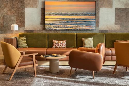 a living room with a couch and chairs at Novotel Paris La Défense Nanterre in Nanterre