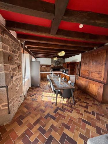 une cuisine avec une table et des chaises dans une pièce dans l'établissement La Maison du Colonel, à Sainte-Eulalie