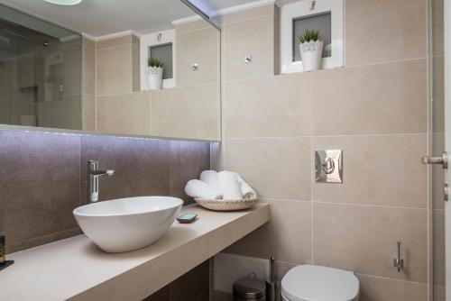 a bathroom with a sink and a toilet at Hermes Beach Front in Stalos