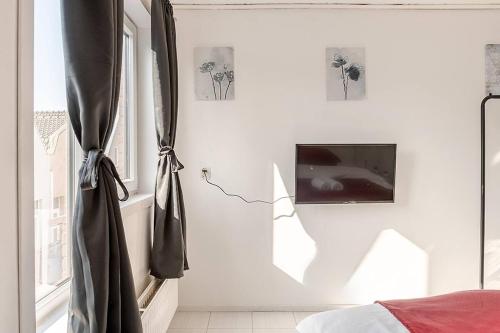 a bedroom with a bed and a tv on a wall at Loopafstand van Lokale Winkels en Zeedijk! - Prachtig Vakantiehuis! in Terneuzen