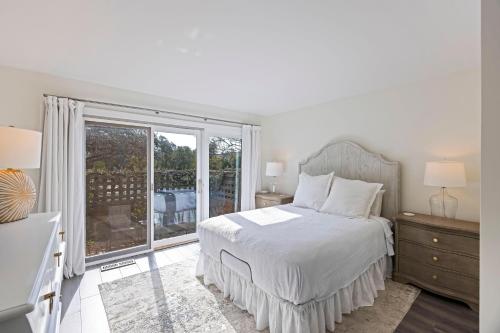 Un dormitorio blanco con una cama y una ventana grande. en BMV1903: 1903 Bohicket Marina Villa, en Seabrook Island
