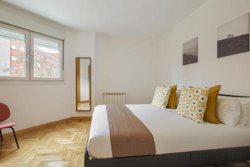 a bedroom with a large bed and a chair at Dobo Getafe Uruguay in Getafe