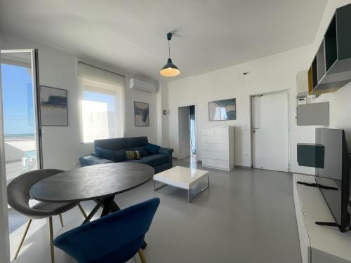 a living room with a table and a blue couch at Canneto Home - Manfredi Homes&Villas in Siponto