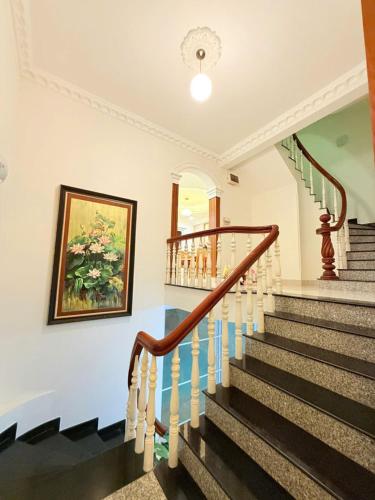 a staircase in a house with a painting on the wall at Villa La Rose Blanc Thảo Điền in Ho Chi Minh City
