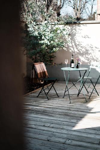 a table with two chairs and a bottle of wine at LA CABANE AFFRANCHIE in Moussy