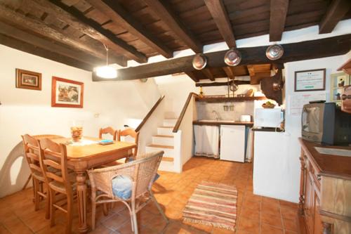 cocina y comedor con mesa y sillas en Casa Rural La Cueva, en Casas del Castañar