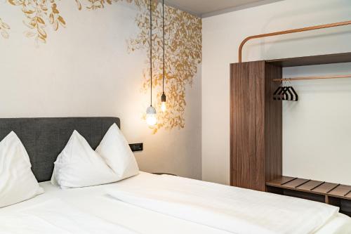 a bedroom with a bed with white pillows at Hotel Lokomotive in Linz