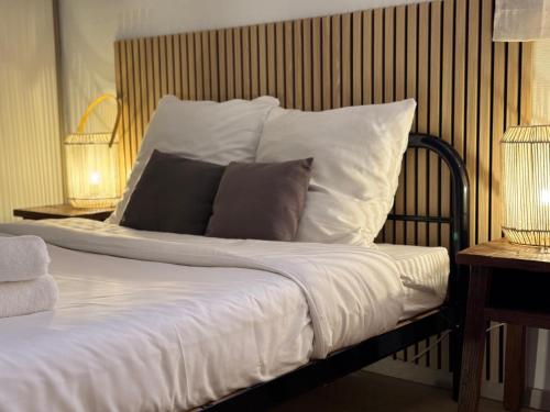 a bed with white sheets and pillows on it at Blue Wave Patio, 5 mins à pied du centre Hossegor in Capbreton