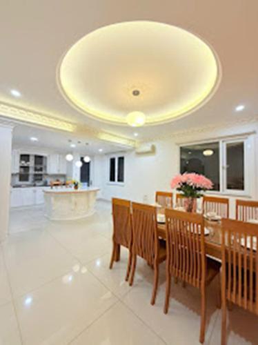 a dining room with a table and chairs and a ceiling at Villa La Rose Blanc Thảo Điền in Ho Chi Minh City