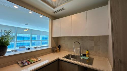 a kitchen with a sink and a large window at Centaurus Apartment Three Bed Mountain View in Islamabad