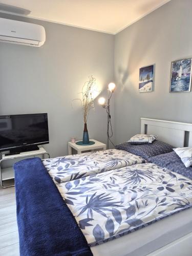 a bedroom with two beds and a flat screen tv at Elegant & Cosy in Wrocław