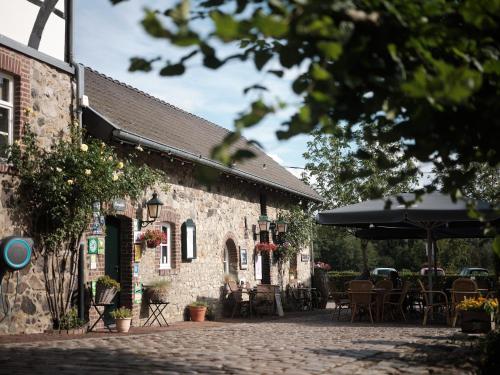 a brick building with tables and chairs and an umbrella at Camping Cottesserhoeve in Vijlen