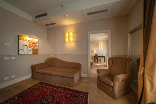 a living room with two chairs and a couch at Hotel Palazzo San Lorenzo & Spa in Colle Val D'Elsa