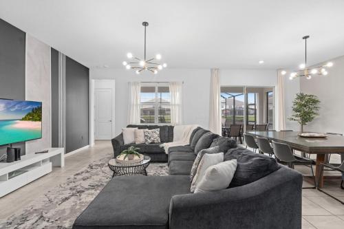 a living room with a couch and a dining room at SUPER JUMBO - 12BD 12BAs SLEEPs 34 - w AMENITIEs in Kissimmee