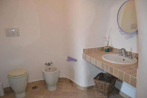 a bathroom with a sink and a toilet and a mirror at Maridea - Cave Apartments in Ponza